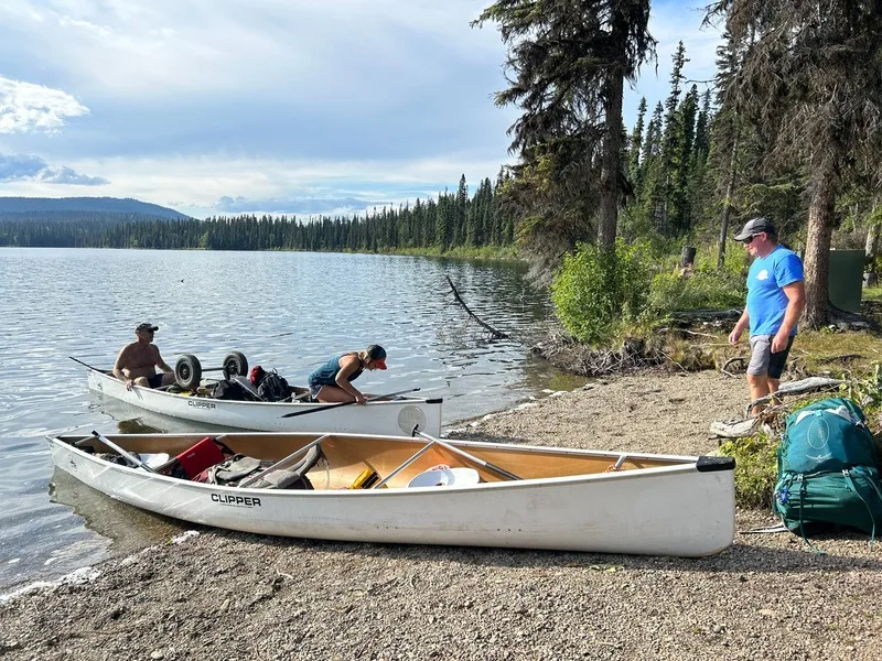 A group of canoes pulled up on a gravel shore on the Bowron Lake Circuit