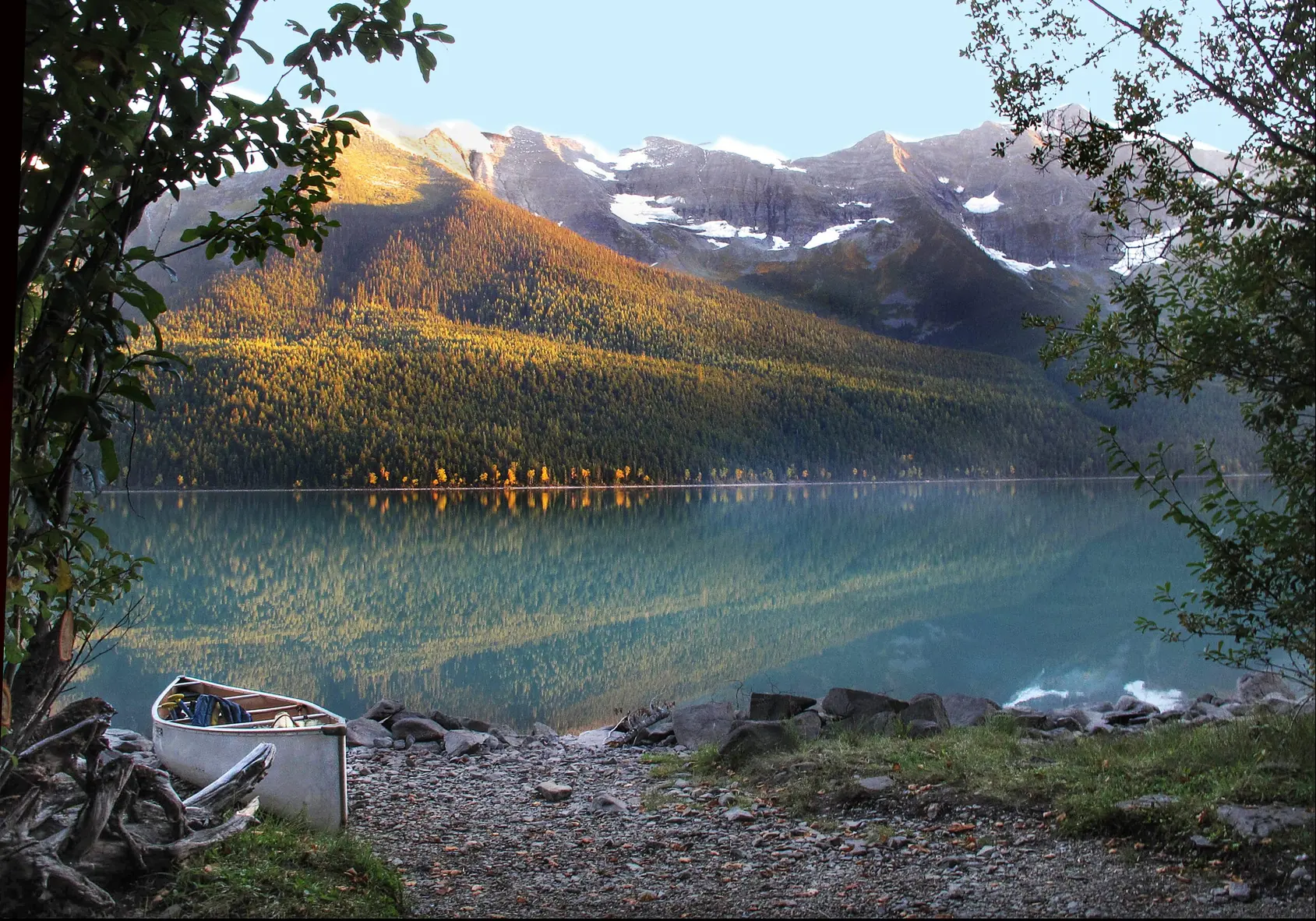 Calm water and forested shoreline on Bowron Lake, British Columbia